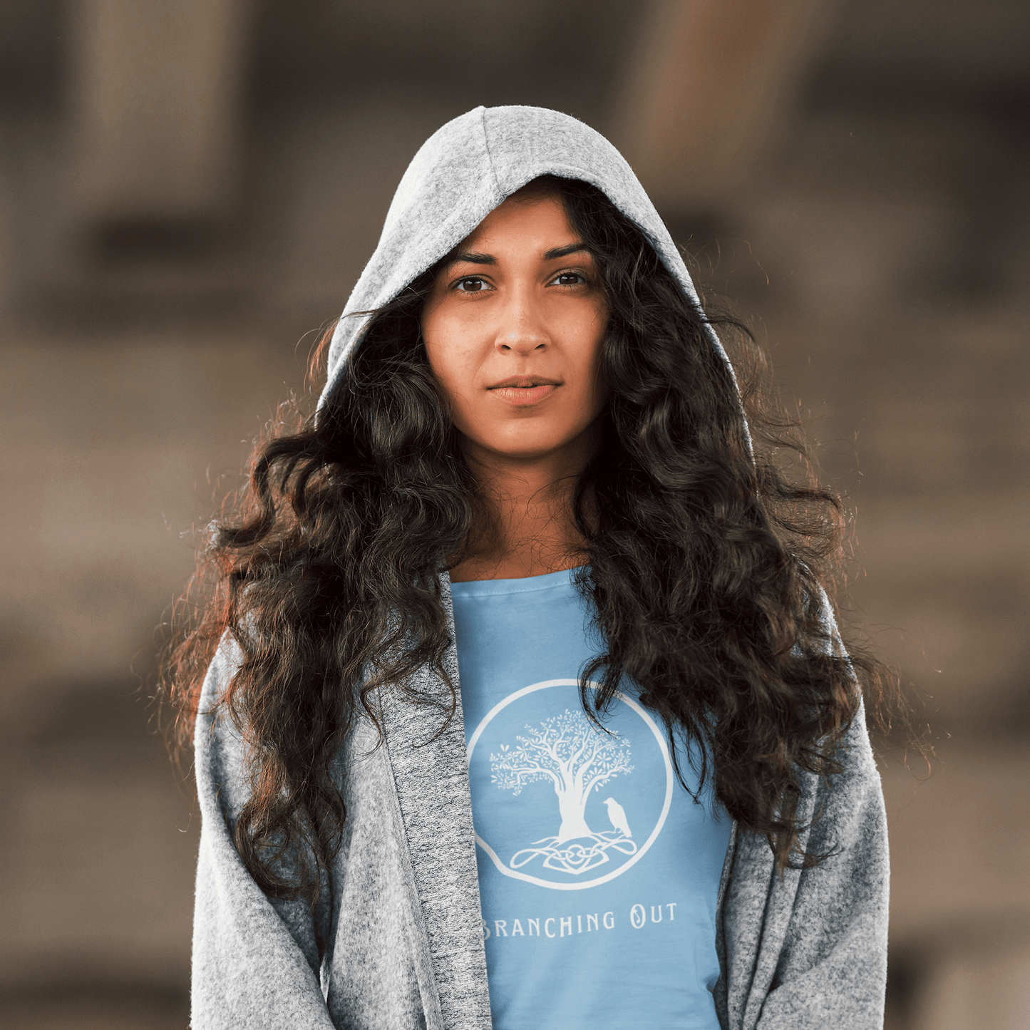 Young woman wearing a light blue bamboo  t-shirt with a celtic stye tree and crow logo