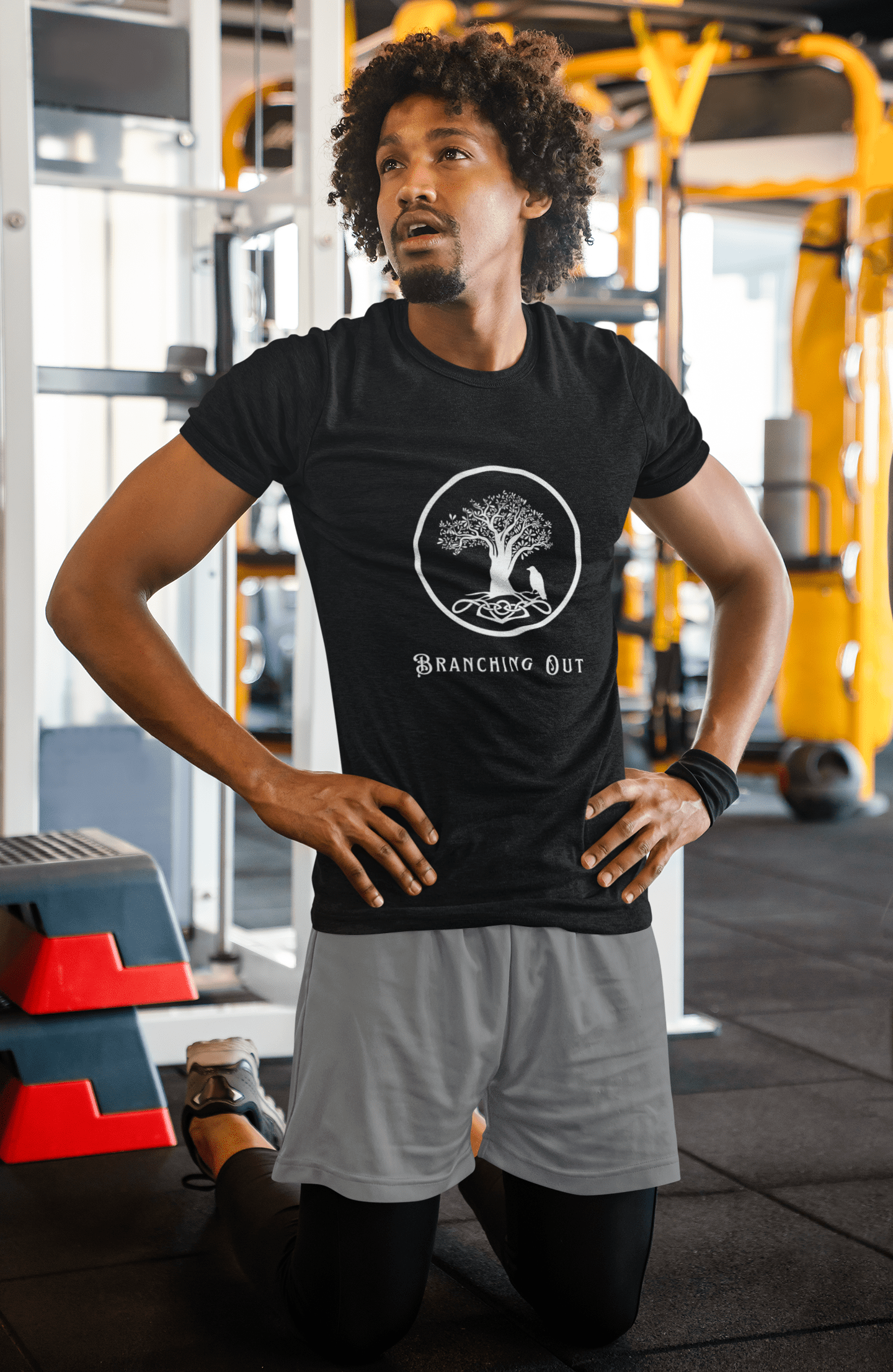 Man in the gym wearing black bamboo t-shirt with a Celtic style tree and crow logo